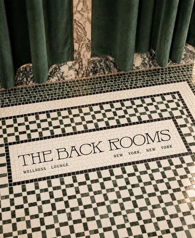 The Back Rooms mosaic tile entry beneath green velvet curtains